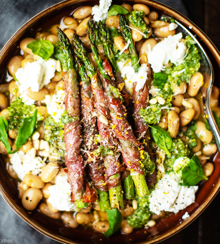 Asparagus wrapped in prosciutto on butter beans